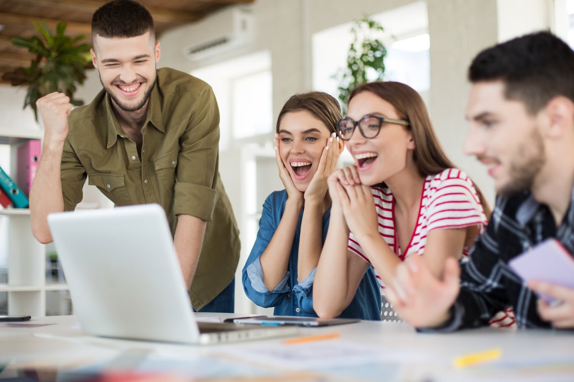 young-joyful-business-people-happily-working-laptop-together-group-smiling-men-women-spending-time-modern-cozy-office